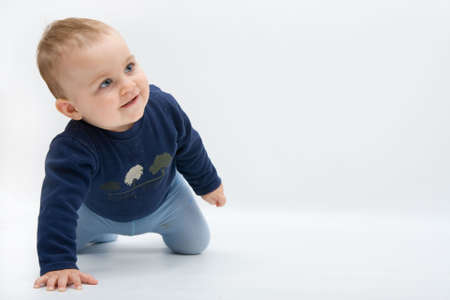 happy baby boy crawling on bright backgroundの写真素材