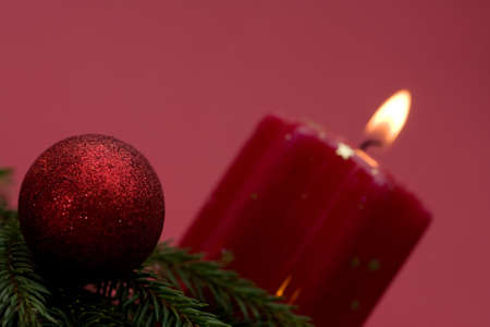 Christmas arrangement of candles and baubles, on red backgroundの写真素材