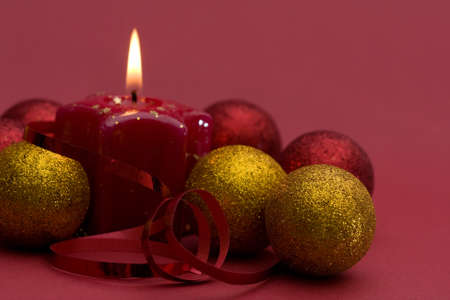 Christmas arrangement of candles and baubles, on red backgroundの写真素材