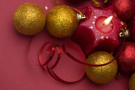 Christmas arrangement of candles and baubles, on red backgroundの写真素材
