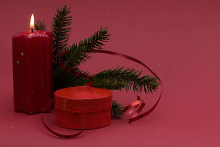 Christmas arrangement of candles and baubles, on red backgroundの写真素材