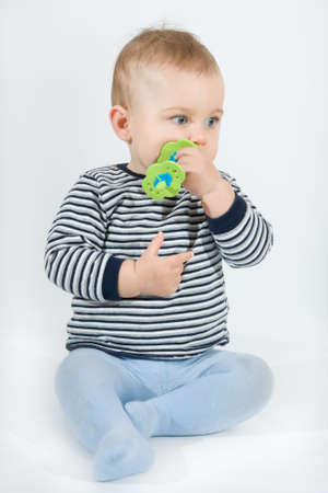 baby boy biting teether, on white