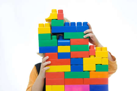 little girl playing with colorful blocks, on whiteの写真素材