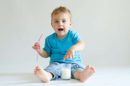 cheeky cute boy with glass of milkの写真素材