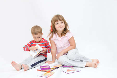 siblings, little boy and a girl, reading togetherの写真素材