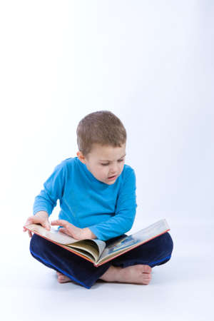 cute, little boy reading a book on whiteの写真素材