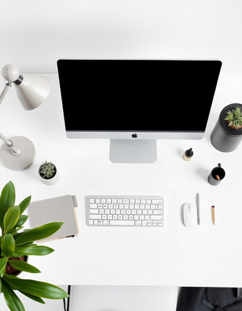 Top view of modern workplace with computer, keyboard, stationery and green plant on white background