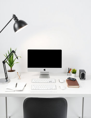 workplace with computer, lamp and stationery on white wall background