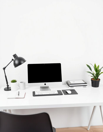 workplace with blank screen computer, stationery and plant on table
