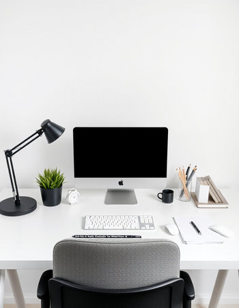 Front view of modern workspace with blank computer screen, stationery, coffee cup and other items....