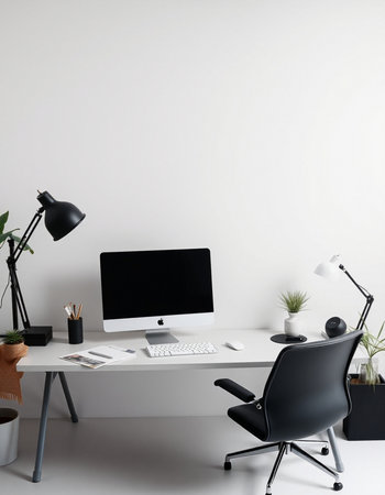 workplace with computer, lamp and stationery on white wall backgroundの写真素材