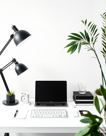Modern workplace with laptop, stationery and green plants on white table