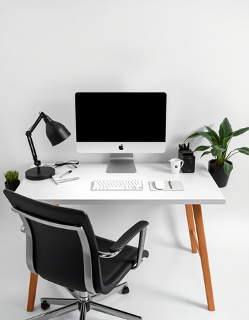 Workplace with computer, lamp, coffee cup and plant on tableの写真素材