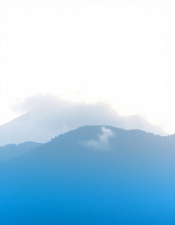 Mountains in the fog. Blue sky with white clouds. Natural background.の写真素材