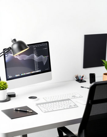 workplace with computer, lamp and other objects on white wall backgroundの写真素材