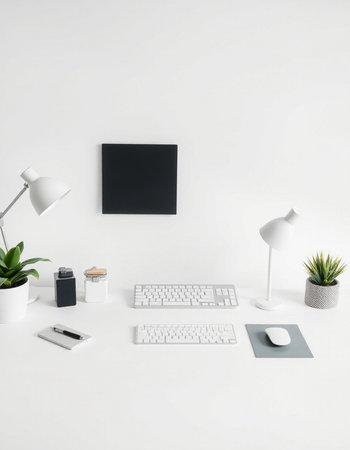 Minimalist workplace with computer, keyboard and accessories on white backgroundの写真素材