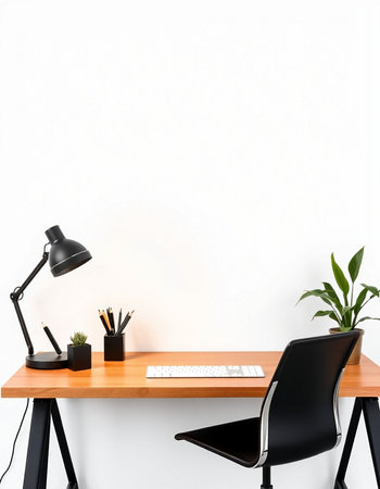 Workplace with computer, lamp and plant on table near white wallの写真素材