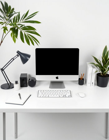 Modern workplace with blank screen computer, keyboard, stationery and plants on white table.の写真素材
