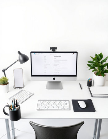 workplace with computer, smartphone and stationery on white wall backgroundの写真素材