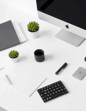 White office desk with computer, notebook and coffee cup.の写真素材