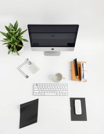 Top view of office desk with computer, supplies and plant on white backgroundの写真素材