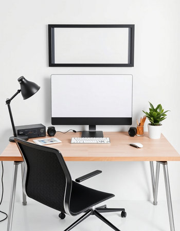 workplace with computer and blank picture frame on wall, 3d renderの写真素材
