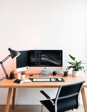 workplace with computer, lamp, coffee cup and plant on tableの写真素材