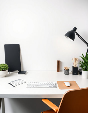 workplace with computer, mouse, lamp and plant on white wallの写真素材