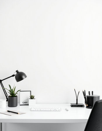 Minimalistic workplace with computer, stationery and copy space on white wall backgroundの写真素材