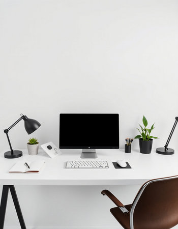 Modern workplace with blank computer screen, stationery and decorations on white wall backgroundの写真素材