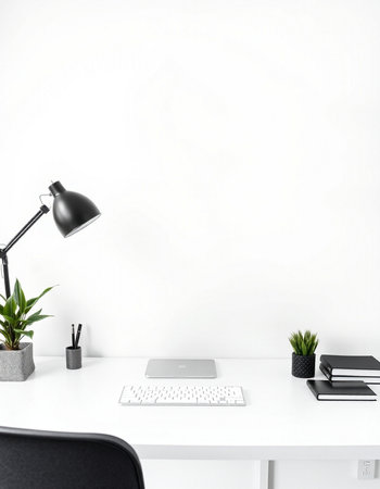 White office desk with laptop, stationery and plant in front of white wallの写真素材