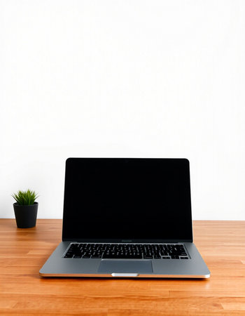 Laptop with blank screen on wooden table and white wall background.の写真素材