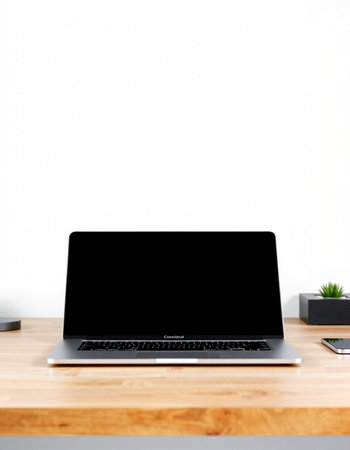 Laptop with blank black screen on wooden desk and white wall backgroundの写真素材