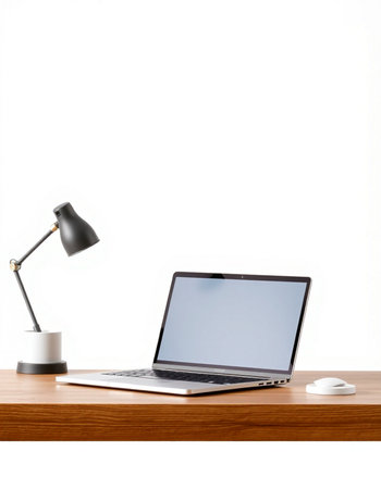 Laptop on wooden desk with lamp and coffee cup on white backgroundの写真素材