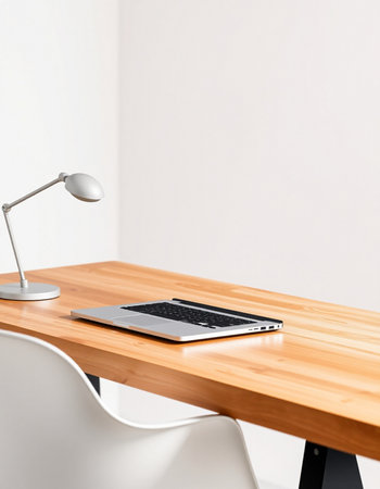 Laptop and lamp on a wooden table in a modern office.の写真素材