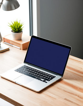 Laptop with blank screen on wooden desk in office. Mock up