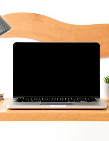Laptop computer with blank screen on wooden shelf in office, stock photo