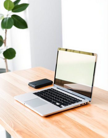 Laptop with blank screen on wooden table in office, stock photoの写真素材