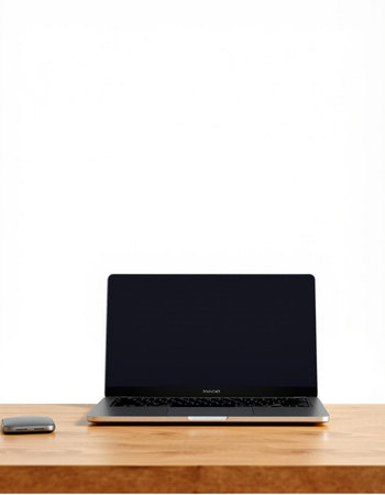 Laptop with blank screen on wooden desk and white wall background.