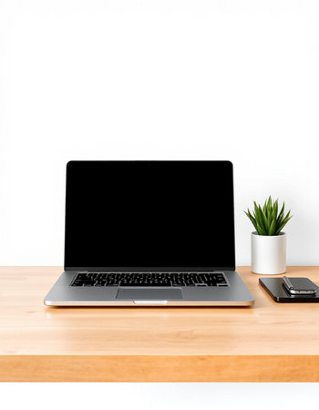 Laptop with blank screen on wooden table and white wall background.
