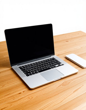Laptop and mobile phone on a wooden table with white background.