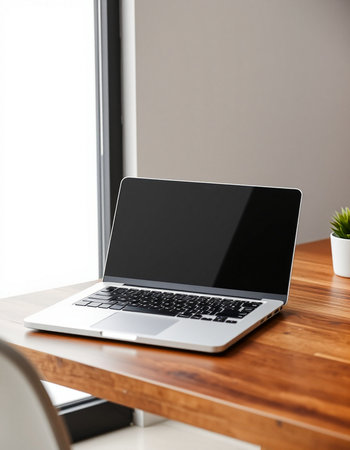 Laptop with blank screen on table in office. Mockup for designの写真素材