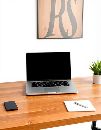 Laptop with blank screen on wooden desk in modern office, stock photo