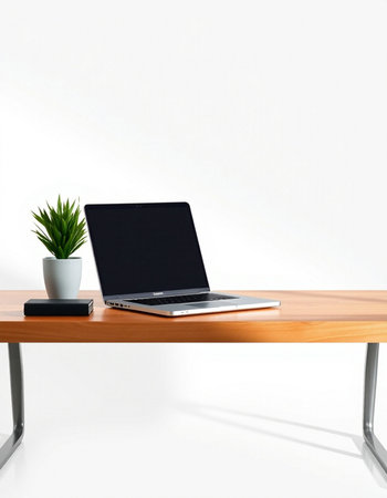 Laptop on a wooden table with a plant on a white background
