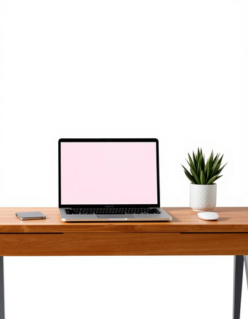 Laptop with blank pink screen on wooden table and white wall background
