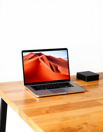 Laptop with red sand dunes on a wooden desk. 3d rendering