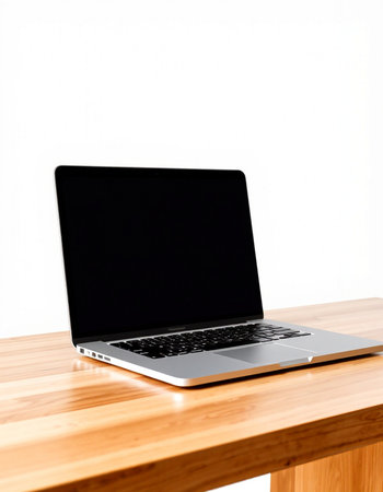 Laptop on wooden table with white wall background, business and technology concept