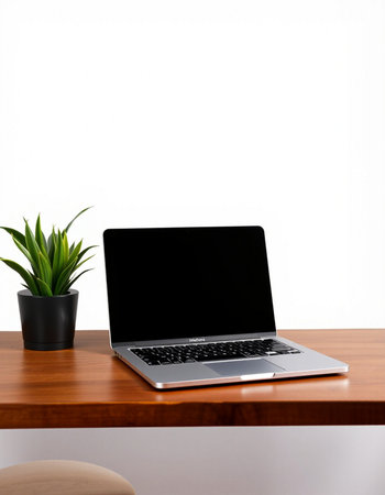 Laptop with blank screen on the wooden table and white wall backgroundの写真素材