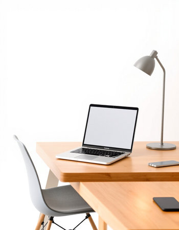 Laptop on wooden desk with lamp and mouse on white wall background