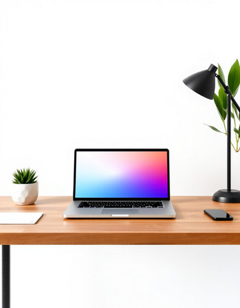 Laptop on wooden table with lamp and plant isolated on white background
